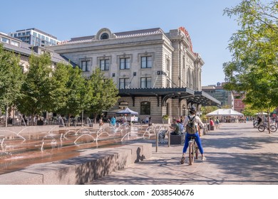 Denver, Colorado - August 28, 2021: A person rides a bicycle in the plaza at Union Station, downtown, in the LoDo (Lower Downtown) neighborhood.