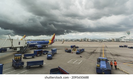 Denver, Colorado July 07, 2021: Dramatic Storm Clouds Hang Over Gate At Airport As Southwest Airlines Crew Rush To Prepare Plane For Next Flight Before The Storm Hits.