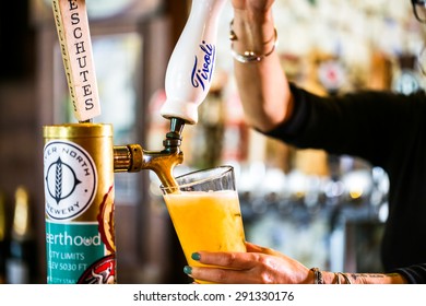 Denver, Colorado, USA-June 3, 2015. Bartender Pouring Draft Beer In The Bar.