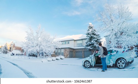 Denver, Colorado, USA-March 19, 2018-POV-Teenager Cleaning His Car From The Spring Snow Storm.