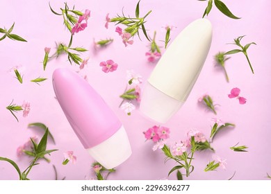 Botellas desodorantes y flores de fondo rosa