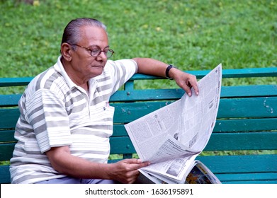 Deolali; Or Devlali; Maharashtra; India; Asia - Sep. 08, 2011- Soft Focus Indian Senior Citizen Reading News Paper In Garden. 