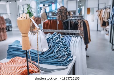 Department of casual and fashion clothing in the outlet in the shopping center. Stylish leather handbag on a wooden mannequin arm
