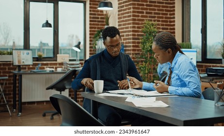 Department members reviewing paperwork in boardroom office, meeting to discuss new business startegy. Startup agency employees collaborating on management vision, research project.