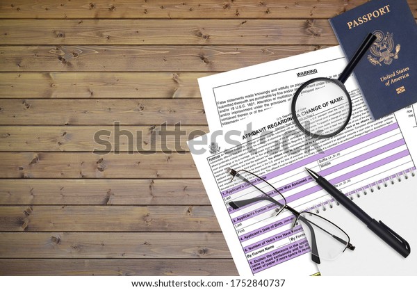 Department of State\
form DS60 Affidavit Regarding a change of name lies on table and\
ready to fill. Paperwork during operations with US Passport\
concept. Flat lay top\
view