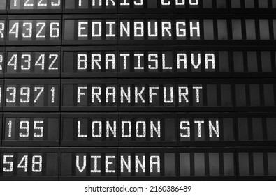 Departure schedule at an airport in Italy. Flights to Edinburgh, Bratislava, Frankfurt, London and Vienna. No airlines symbols visible. Black and white vintage style photo.