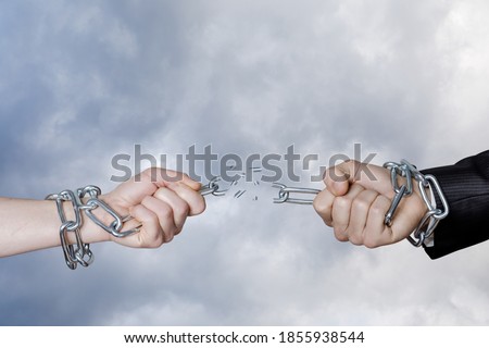 Dependency break concept. Hands break the chain against the background of the sky.