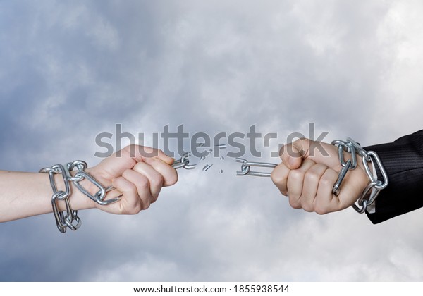 Dependency break concept. Hands break the chain\
against the background of the\
sky.