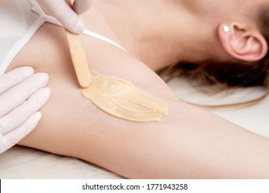 Depilation And Epilation Female Armpit With Liquid Sugar Paste By Spatula. Hand Of Cosmetologist Applying Wax Paste On Armpit. Smooth Underarm Concept