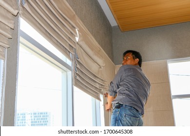 Depok, Indonesia - August 23, 2017: Craftsman is taking care of the curtains in the office lobby. Roman shade curtain - Shutterstock ID 1700645308