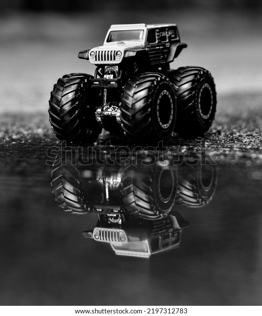 Depok, West Java, Indonesia - September 1st 2022:\
diecast jeep monster truck with reflection on water, black and\
white photo, isolated\
picture