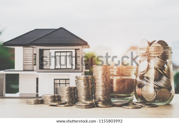Deposit money with model house.Real estate and\
mortgage investment\
concept.