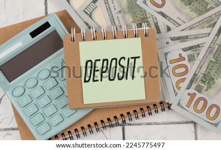 DEPOSIT text on a notebook with chart, calculator and pen