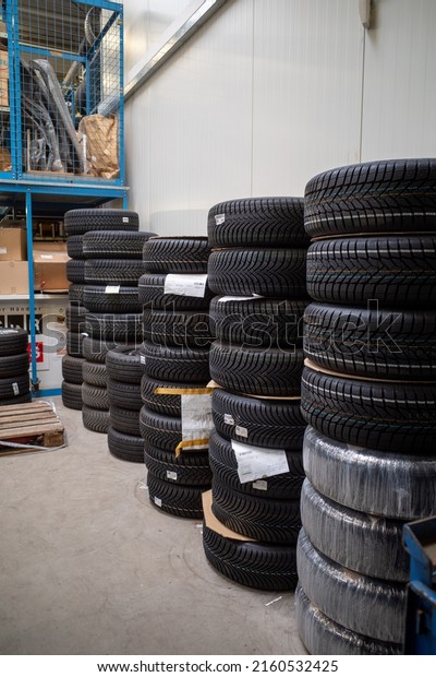 in the depot of a car repair shop\
there are many summer tires ready for a wheel\
change