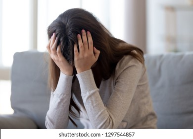 Depressed Abused Desperate Young Woman Holding Head In Hands Feeling Hurt Upset, Sad Offended Teen Girl Cry Alone At Home, Heartbroken Frustrated Teenager Victim Having Psychological Trauma Problem