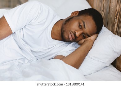 Depressed African American Man Lying Awake Thinking Of Problems And Having Insomnia In Bedroom At Home At Night. Male Stress And Depression, Sleeplessness And Apathy Concept.