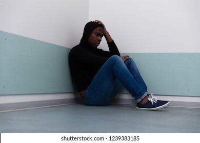 Depressed African Man Sitting Alone On Floor