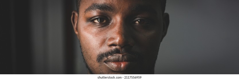 Depressed African man thinking about disappointed love and looking down in dark room.Concept of Broken Heart and Valentine's Day - Powered by Shutterstock
