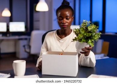 Depressed African Woman After Being Dismissed From Work Late At Night. Unemployed Packing Things Late At Night. Woman Leaving Workplace Office In Midnight.