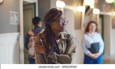 Depressed Afro-american Female Student Walking In College Corridor