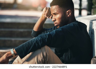 Depressed, angry and black man upset, tired and unhappy outdoor in city, stare and frustrated. Mental health, African American male and young guy with problem, fail and depression being disappointed. - Shutterstock ID 2227464891