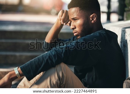 Depressed, angry and black man upset, tired and unhappy outdoor in city, stare and frustrated. Mental health, African American male and young guy with problem, fail and depression being disappointed.