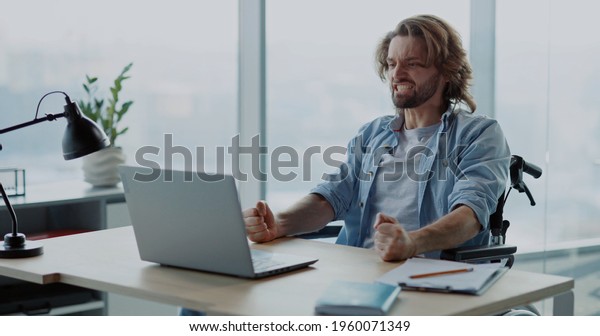 Depressed angry young man\
office worker losing computer data having problem internet\
connection screaming inside office corporate space. Emotions.\
Disabled person.