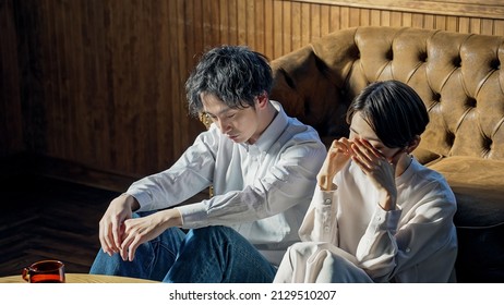 Depressed Asian couple in the room. - Shutterstock ID 2129510207