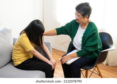 Depressed Asian Girl Having Consultation With Psychologist At Clinic.