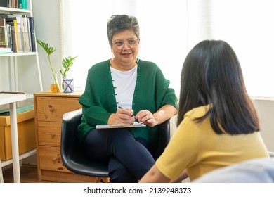 Depressed Asian Girl Having Consultation With Psychologist At Clinic.