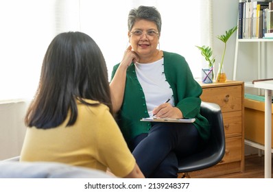 Depressed Asian Girl Having Consultation With Psychologist At Clinic.