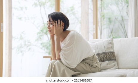 Depressed Asian middle aged woman in the room. - Shutterstock ID 2183481687