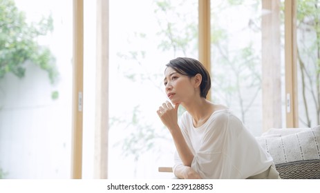 Depressed Asian middle aged woman in the room. - Shutterstock ID 2239128853