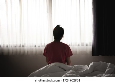 Depressed asian woman has sad and lonely feel sitting on the bed in the morning.