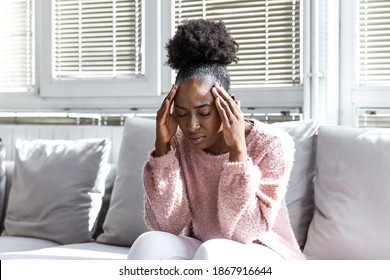 Depressed Black Young Woman Sit On Sofa Down Upset Having Personal Relationships Problems, Stressed Millennial African American Girl Touch Head Feel Despair Mourning Or Grieving Of Loss