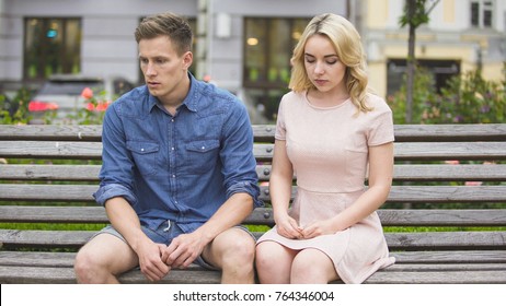 Depressed Boyfriend And Girlfriend Sitting On Bench After Fight, Breaking Up