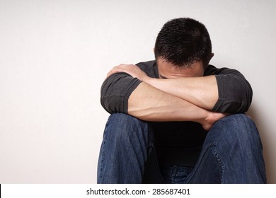 depressed brokenhearted young man hiding his face                               