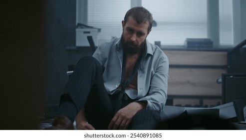 Depressed businessman sits on the floor after fit of rage over unsuccessful business deal. Upset office employee breathes heavily after destroying office room. Financial crisis or firing. Job burnout. - Powered by Shutterstock