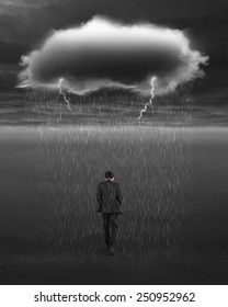 Depressed Businessman Walking With Dark Cloud Of Rain And Lightning Over His Head