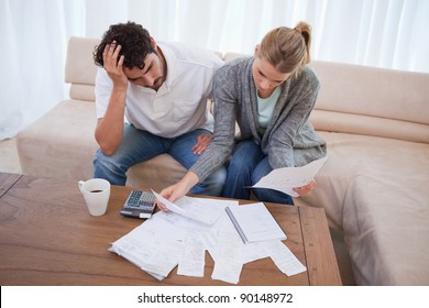 Depressed couple doing their accounting in their living room - Powered by Shutterstock