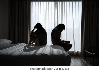 Depressed Couple Having A Problem Sitting Head In Hands In The Dark Bedroom, Negative Emotion And Mental Health Concept