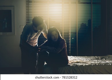 Depressed Couple Husband And Wife Sitting Head In Hands On The Bed In The Dark Bedroom With Low Light Environment, Dramatic Concept