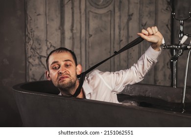 Depressed Crazy Man Mental Health In Bathtub In Bathroom At Home. Crazy Person Showing Human Emotions. Concept Apathy, Anxiety, Illness, Trouble, Creative Decline. Copy Space