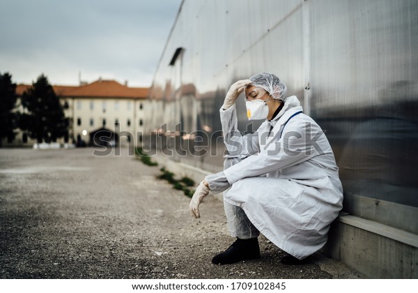 Depressed\
crying doctor with mask having mental breakdown.Fear,anxiety,panic\
attack due to coronavirus outbreak.Psychological effects of\
COVID-19.PTSD.Mental health,coping with\
death