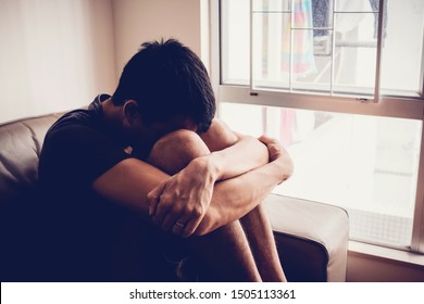 Depressed, despair and anxiety young man sitting alone at home, social distancing,isolation, mental health, men health, in debt, bankruptcy concept