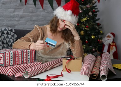 Depressed Frustrated Woman Wrapping Christmas Gift Boxes Thinking About Expenses And Overspending During Winter Holidays. Winter Holiday Stress Concept.