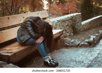 Depressed Girl Sitting On Bench In The Park