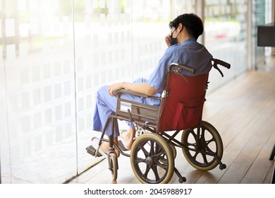Depressed Handicapped Male Patient In Wheelchair Looking Out Through The Window, Paraplegic, Disabled Man