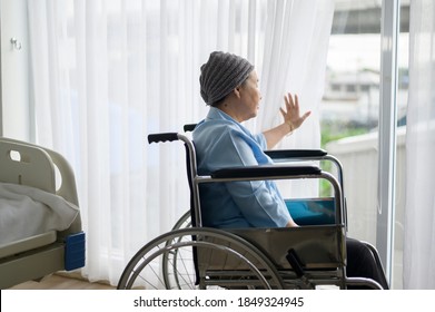 A Depressed And Hopeless Asian Cancer Patient Woman Wearing Head Scarf In Hospital.