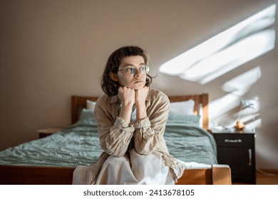 Depressed lonely woman sitting on cozy bed sadly look at window feeling anxiety. Alone girl suffering from emotional pain having life troubles, problems. Mental disorder anhedonia, stress discomfort - Powered by Shutterstock